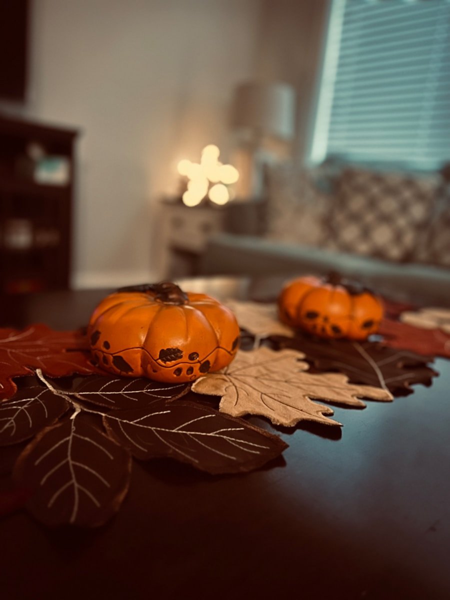 a wooden table topped with pumpkins and leaves