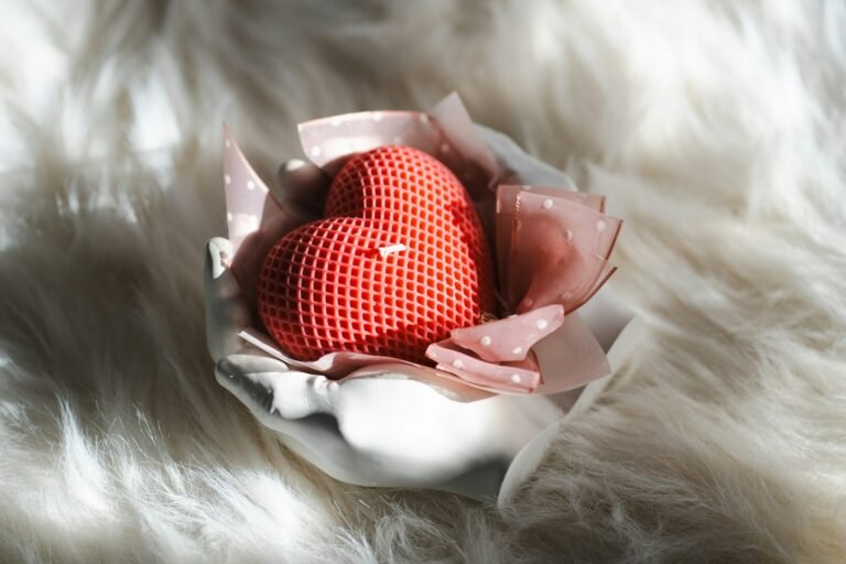 A red heart sitting on top of a piece of cloth