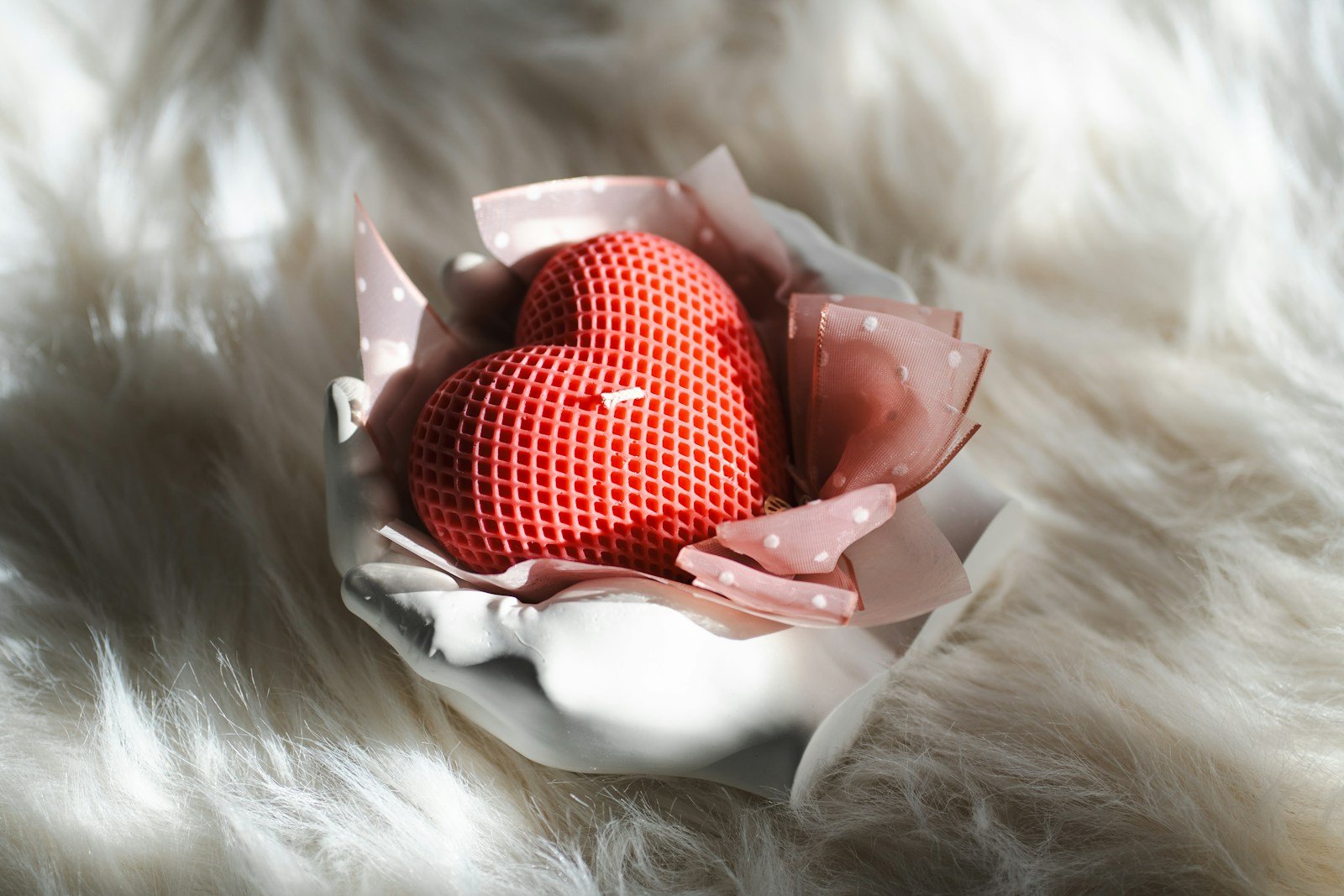A red heart sitting on top of a piece of cloth