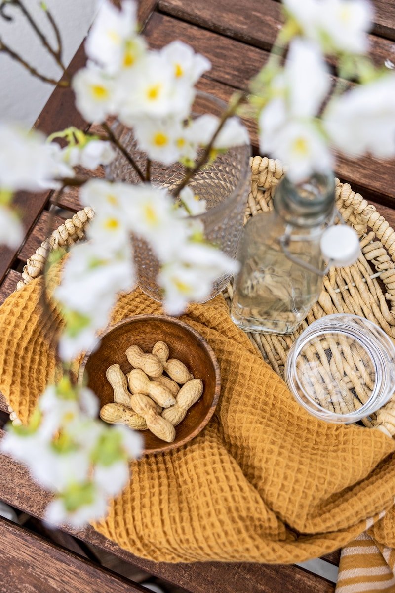 A bowl of peanuts sitting on top of a wooden table