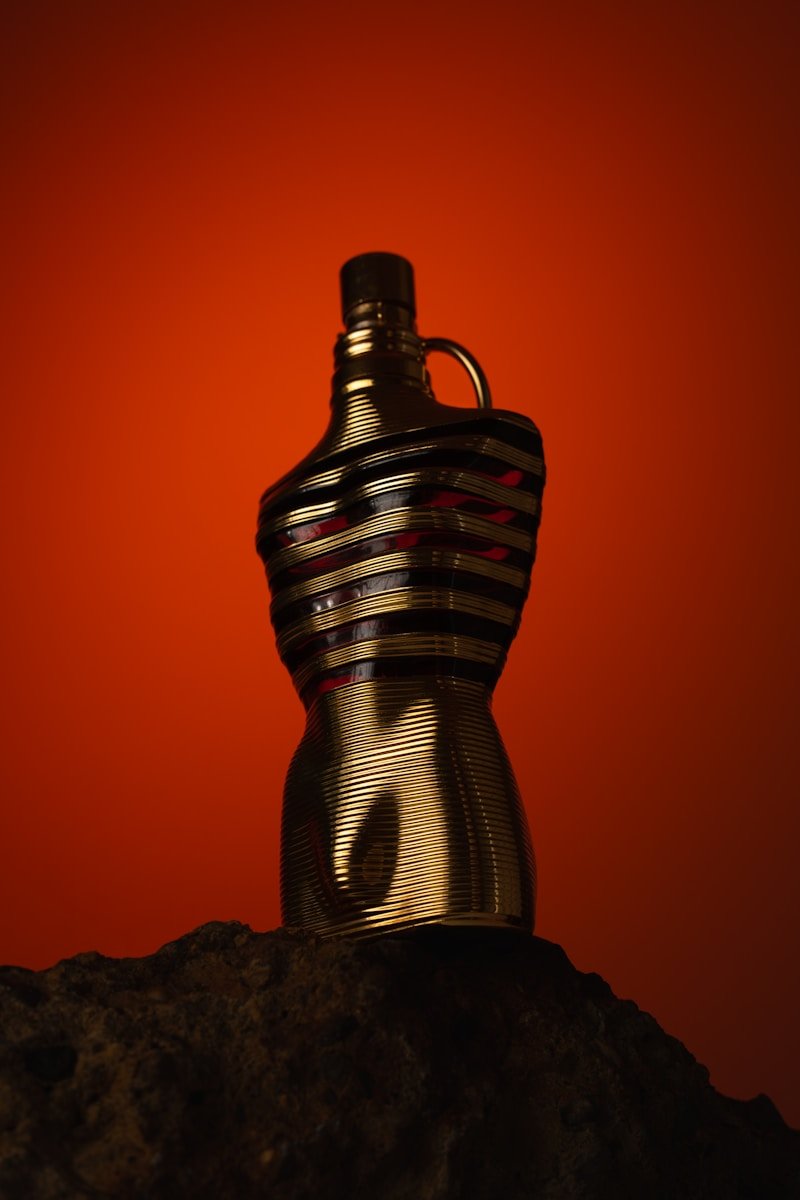 Gold bottle with striped design on rock