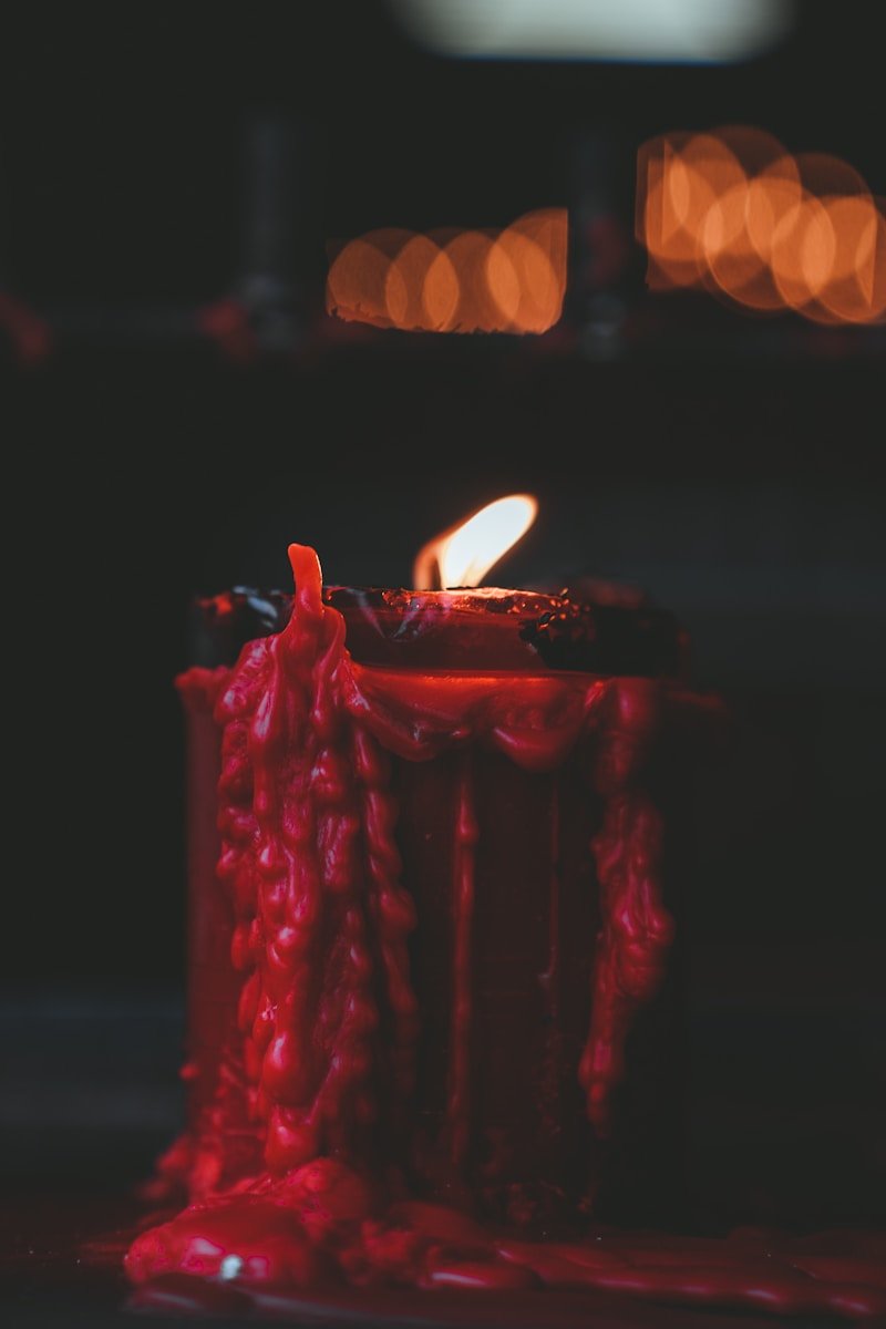 red lighted candle on black table