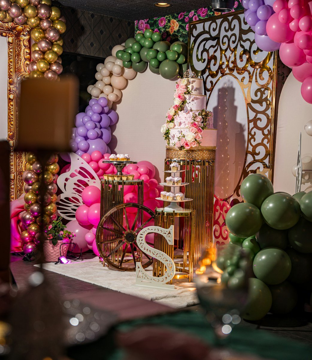 A festive party setup with balloons, cake, and decorations.