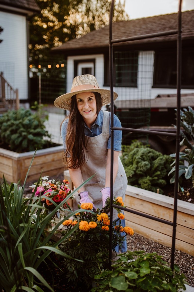 A woman wearing a hat and gardening gloves