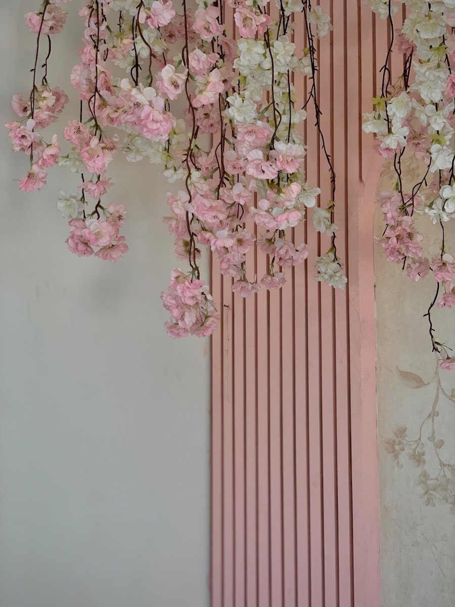 a pink wall with a bunch of flowers hanging from it
