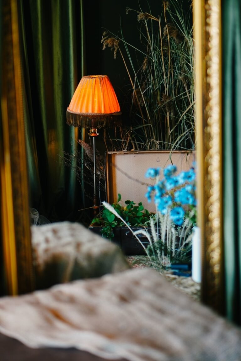 A bedroom with a bed, a lamp and a mirror