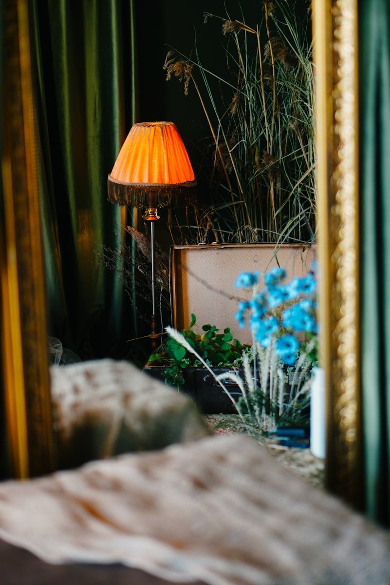 A bedroom with a bed, a lamp and a mirror