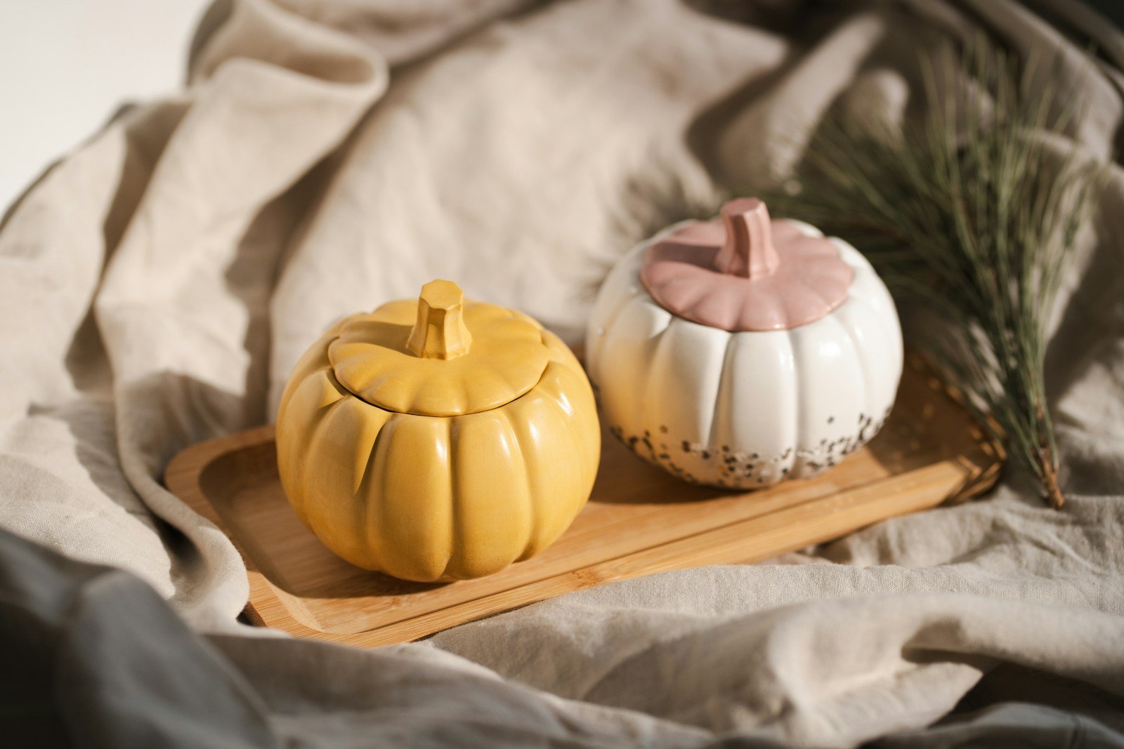 A couple of small pumpkins sitting on top of a wooden tray