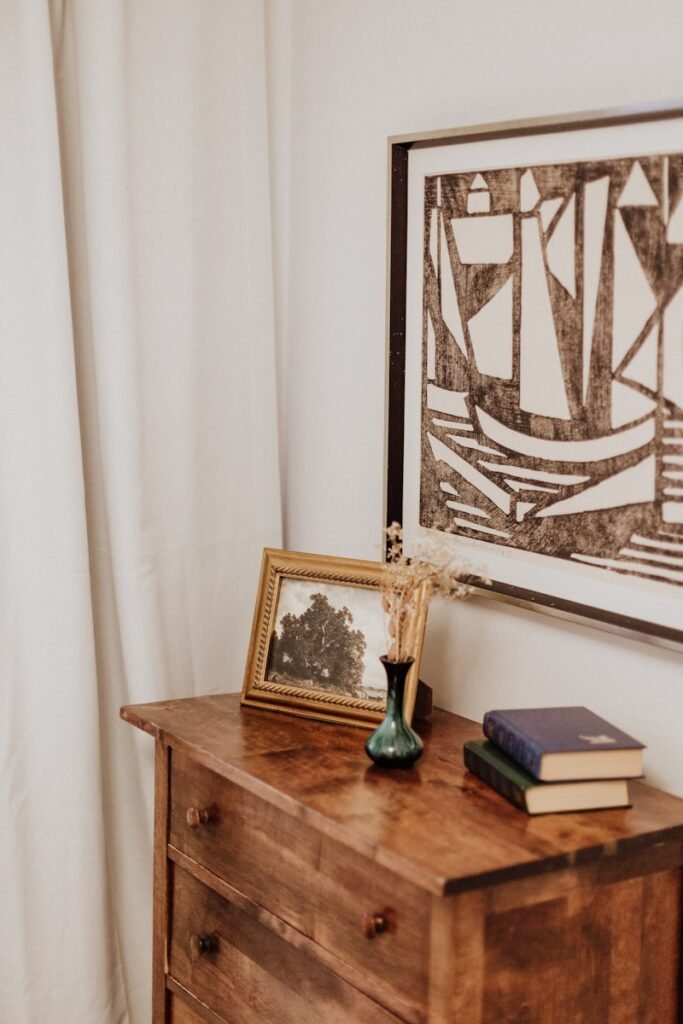 A wooden dresser with a picture on top of it