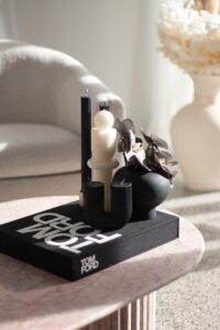 a black and white object with a candle on a black surface